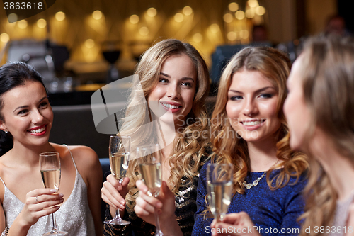 Image of happy women with champagne glasses at night club