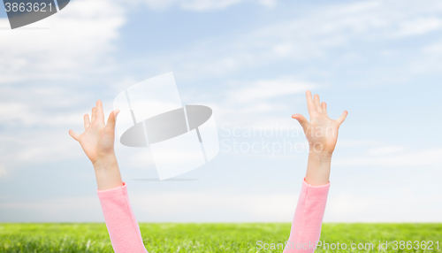 Image of close up of little child hands raised upwards