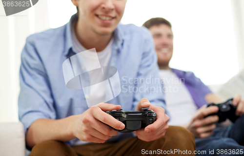 Image of close up of friends playing video games at home