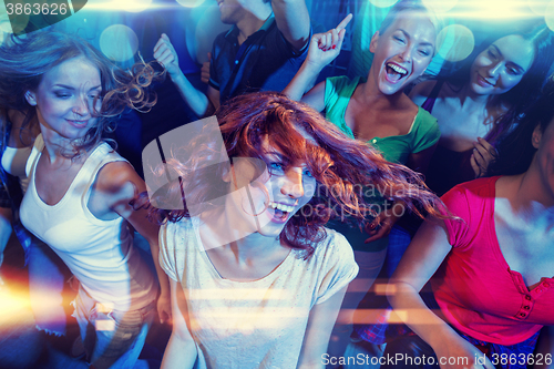 Image of smiling friends dancing in club