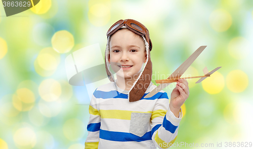 Image of happy little boy in aviator hat with airplane