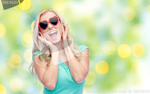 Image of happy young woman in heart shape sunglasses