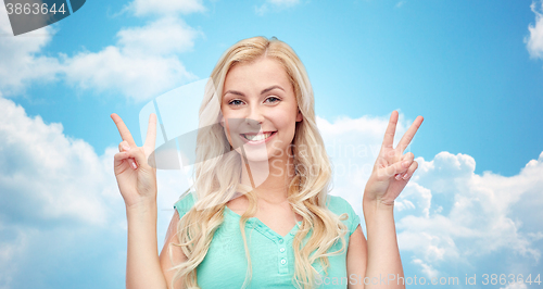 Image of smiling young woman or teenage girl showing peace