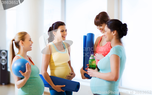 Image of group of happy pregnant women talking in gym