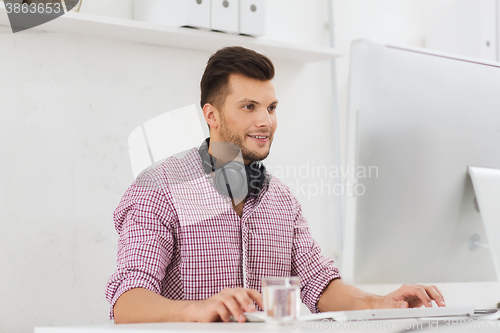 Image of creative man with headphones and computer