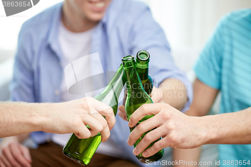 Image of close up of male friends drinking beer at home