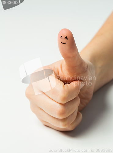 Image of close up of hand showing thumb with smiley face