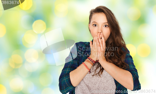 Image of scared teenage girl over green holidays lights