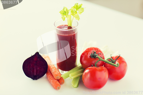 Image of close up of fresh juice and vegetables on table