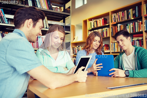 Image of happy students with tablet pc in library