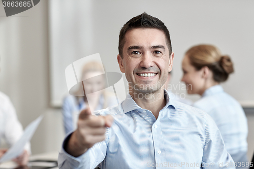 Image of group of smiling businesspeople meeting in office