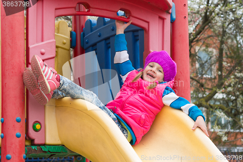Image of Five-year girl sitting on top of fun childrens slides