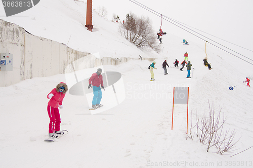 Image of Dombay, Russia - February 7, 2015: People ride on the snow-covered slopes of the ski resort Dombai