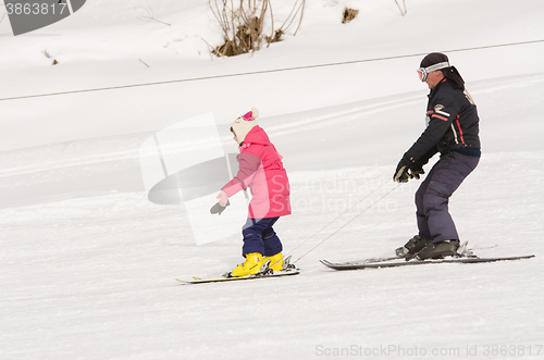 Image of Dombay, Russia - February 7, 2015: A man learns to ski teenage girl on a snow-covered slope ski resort Dombai