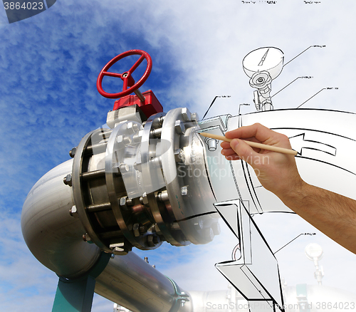 Image of man\'s hand draws a design of factory combined with photo of mode