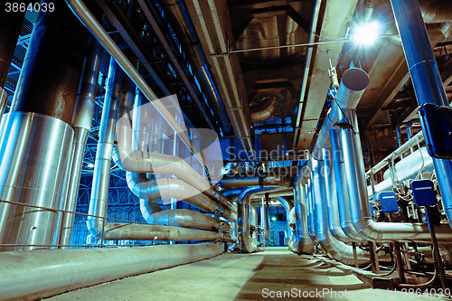 Image of different size and shaped pipes and valves at a power plant 