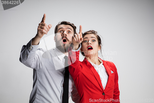 Image of The surprised business man and woman showing up on a gray background