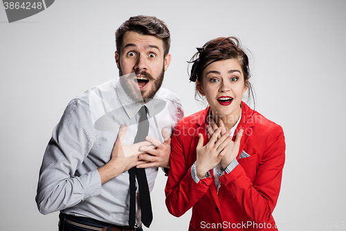 Image of The surprised business man and woman smiling on a gray background