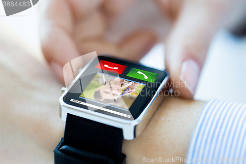 Image of close up of hands with incoming call on smartwatch