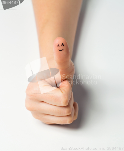 Image of close up of hand showing thumb with smiley face