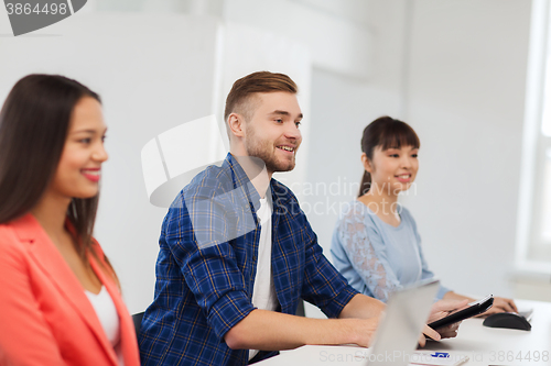 Image of happy creative team or students working at office