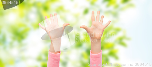 Image of close up of little child hands raised upwards