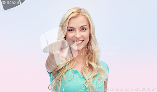 Image of happy young woman pointing finger to you