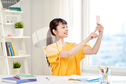 Image of asian woman student taking selfie with smartphone