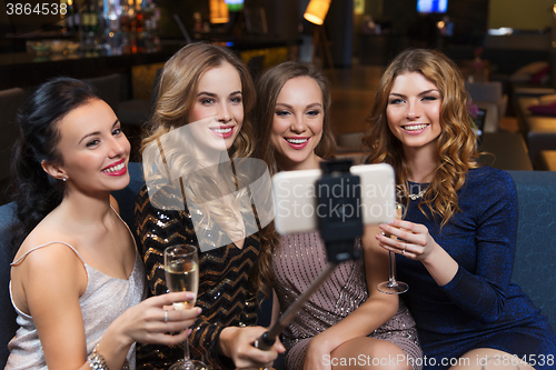 Image of women with smartphone taking selfie at night club