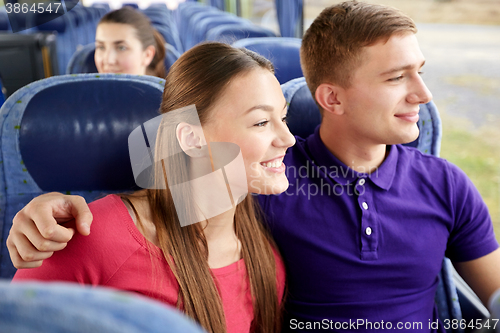 Image of happy teenage couple or passengers in travel bus