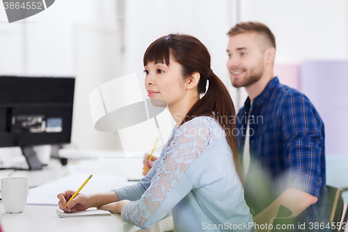 Image of happy creative team or students working at office