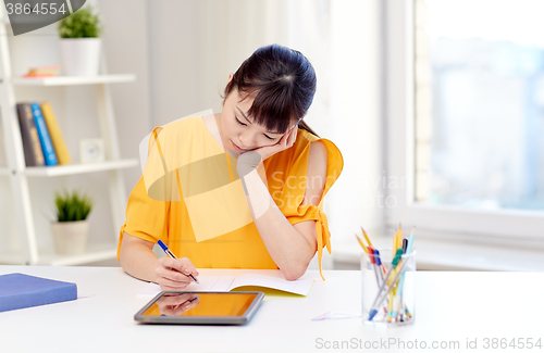 Image of bored asian woman student with tablet pc at home