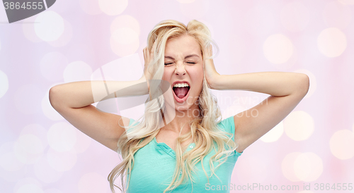 Image of young woman holding to her head and screaming