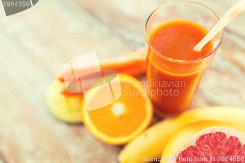 Image of close up of fresh juice glass and fruits on table
