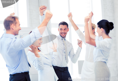 Image of business team celebrating victory in office