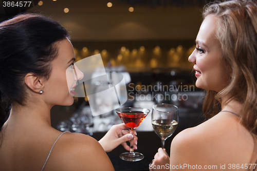 Image of happy women with drinks at night club bar