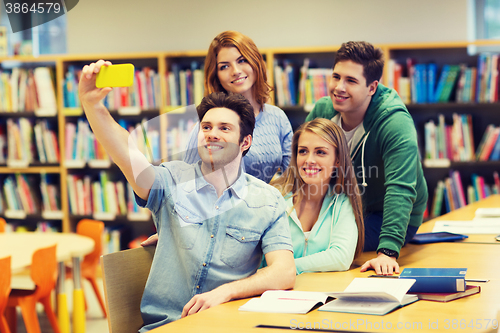 Image of students with smartphone taking selfie in library