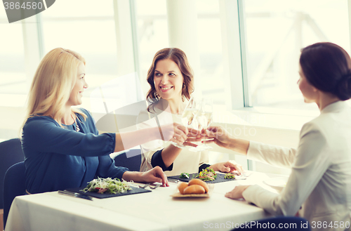 Image of happy women drinking champagne at restaurant