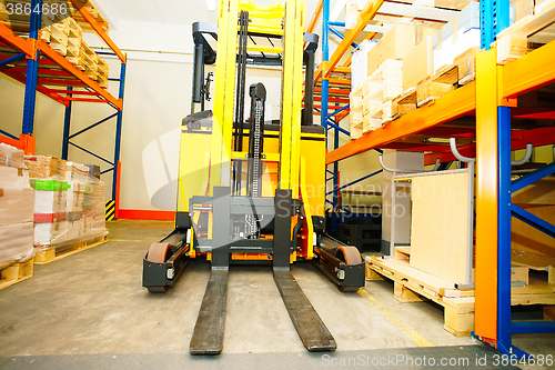 Image of Forklift, shelves and racks with pallets in distribution warehou