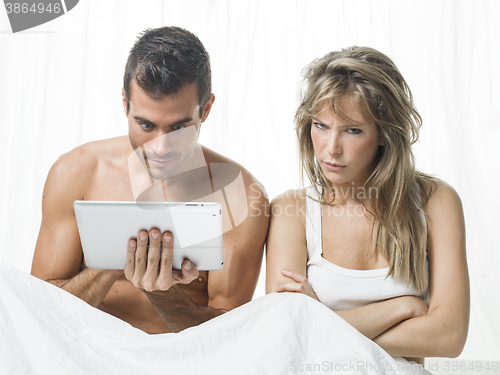 Image of uncommunicative couple on bed in white 