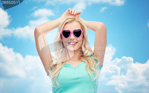 Image of happy young woman in heart shape sunglasses