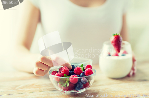 Image of close up of woman hands with yogurt and berries