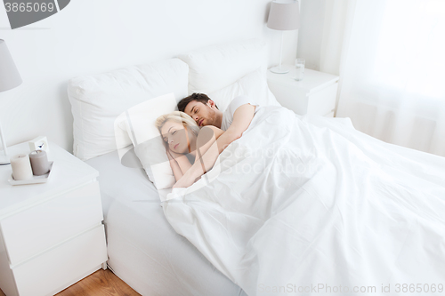 Image of happy couple sleeping in bed at home