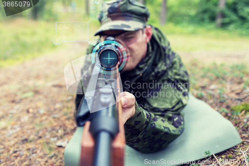 Image of close up of soldier or sniper with gun in forest