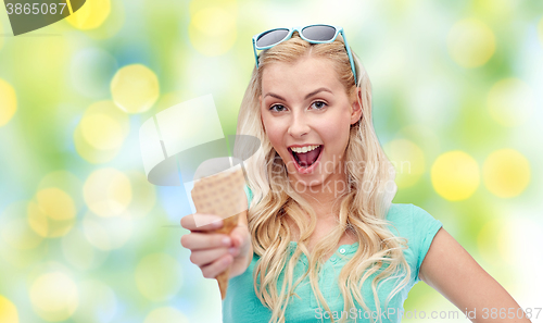 Image of happy young woman in sunglasses eating ice cream