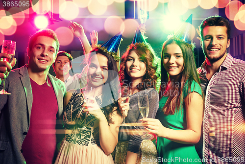 Image of smiling friends with glasses of champagne in club