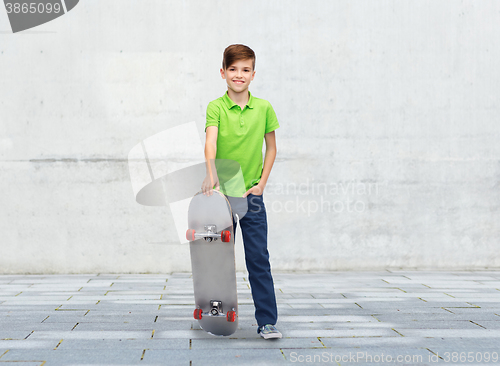 Image of happy boy with skateboard over street background