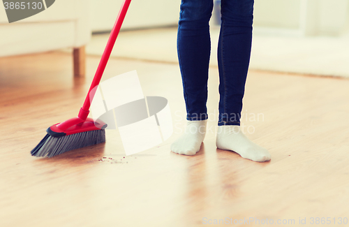 Image of close up of woman legs with broom sweeping floor