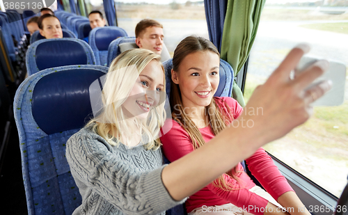 Image of women taking selfie by smartphone in travel bus