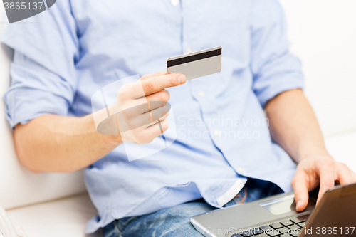 Image of close up of man with laptop and credit card